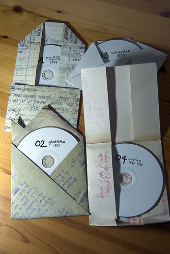 The four CDs inside the Humpback Oak "Oaksongs" box and their packaging.