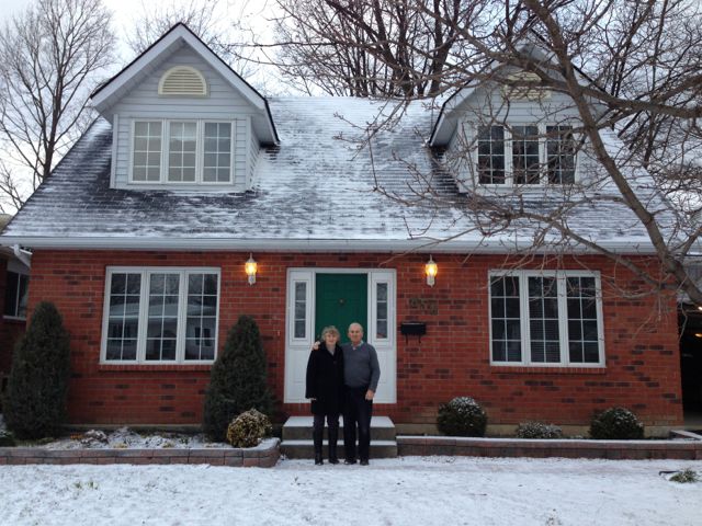 Mom and Dad in front of their house.